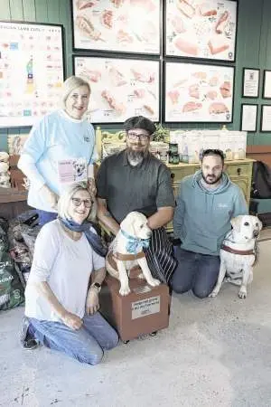 Ellen Mortimore (kneeling), Sue Clarke, Nathan Gunter, and Bobby Brien with guide dog Zeek and the fundraising box at Darling Street Meat House, Dubbo. Photos: Dubbo Photo News.