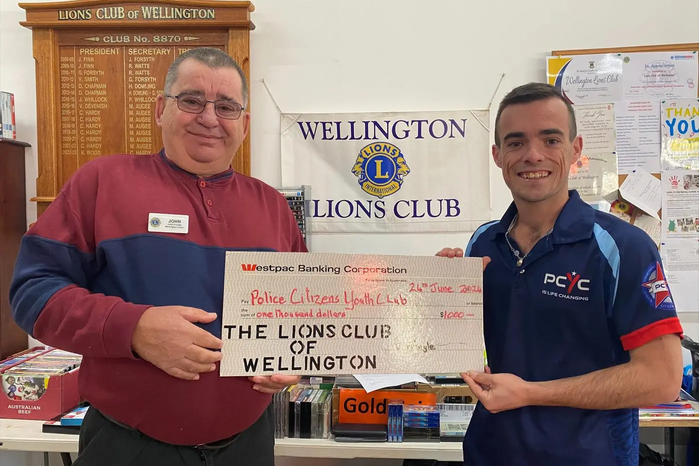 Proof\\'s in the pudding for the good deeds of Wellington Lions with Club President John Pringle presenting a cheque to Auden Carr of Wellington PCYC, with funds raised from their Pre-Loved Book Fair . Photo: Supplied.