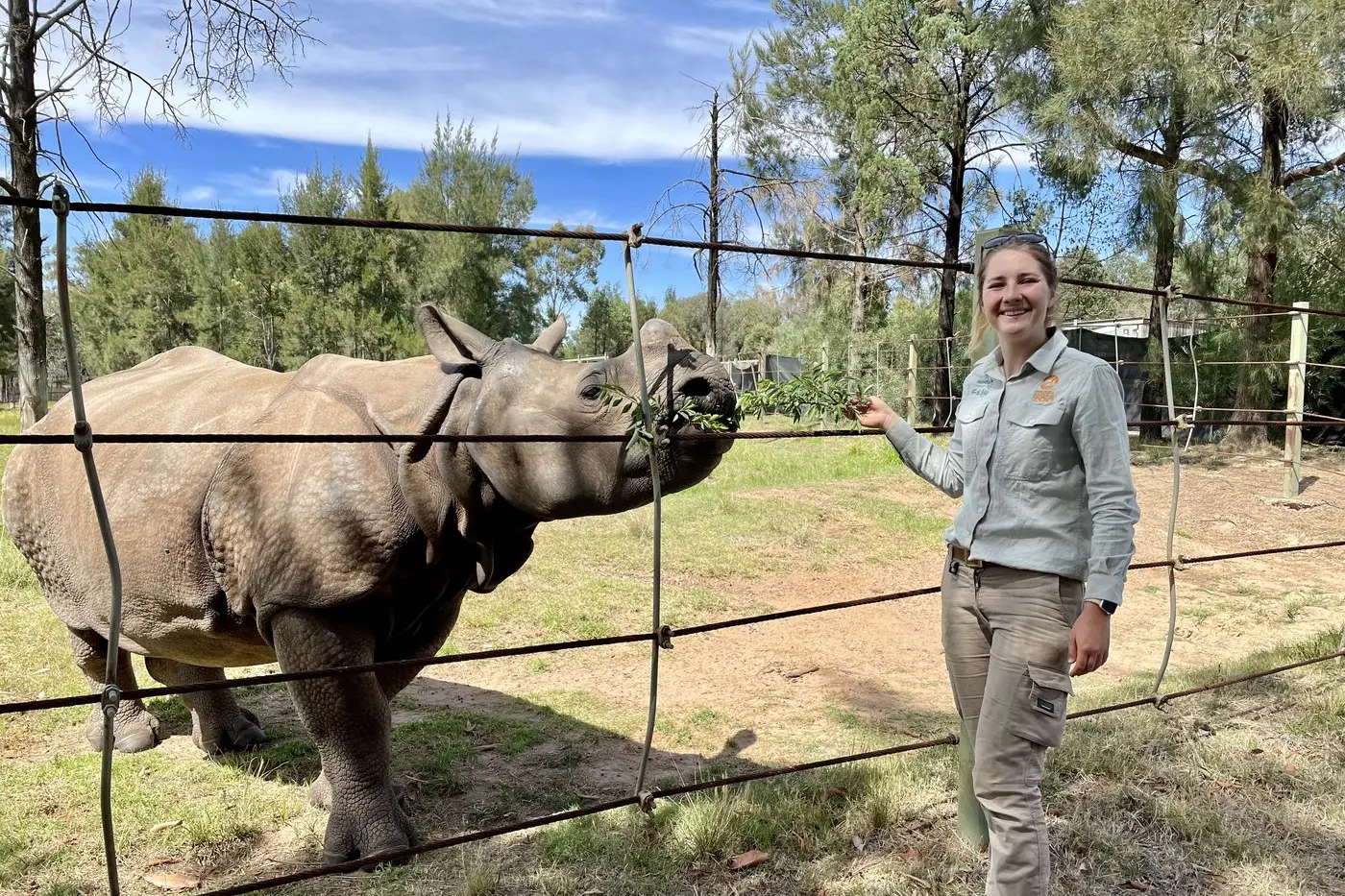 Taronga Western Plains Zoo Keeper Amy Sturrock behind the scenes with Greater One-horned Rhino Hari. Photo: Taronga Western Plains Zoo.
