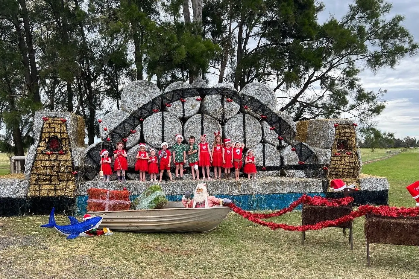 Bob and Jenny Johnson\\'s grandchildren with a Christmas-themed Sydney Harbour Bridge made out of hay bales. Photo: Keira Johnson