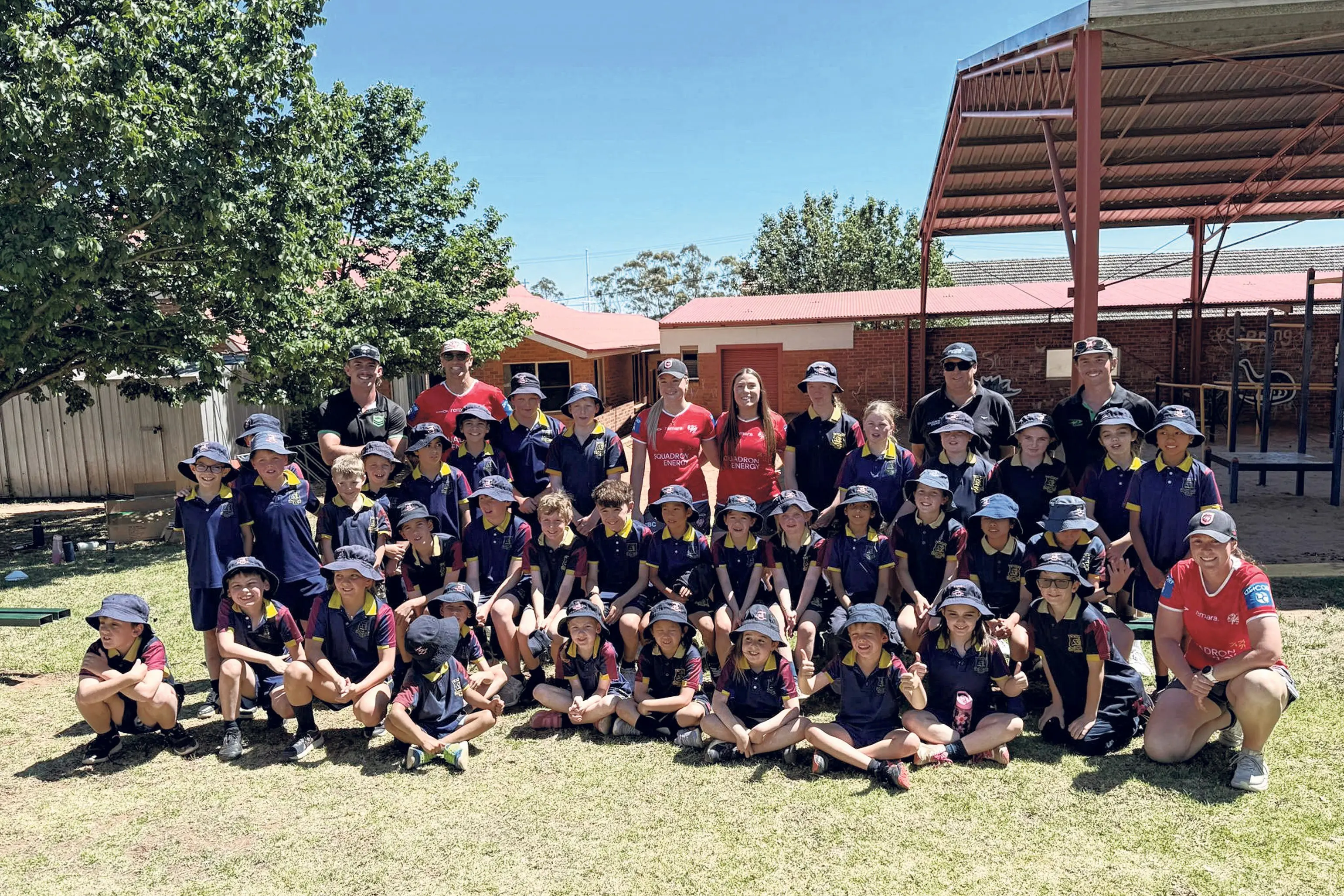 <p>Dunedoo Central School students welcome Dragons\\' NRLW stars Keele Browne and Ella Koster. Photo: Squadron Energy</p>\\n