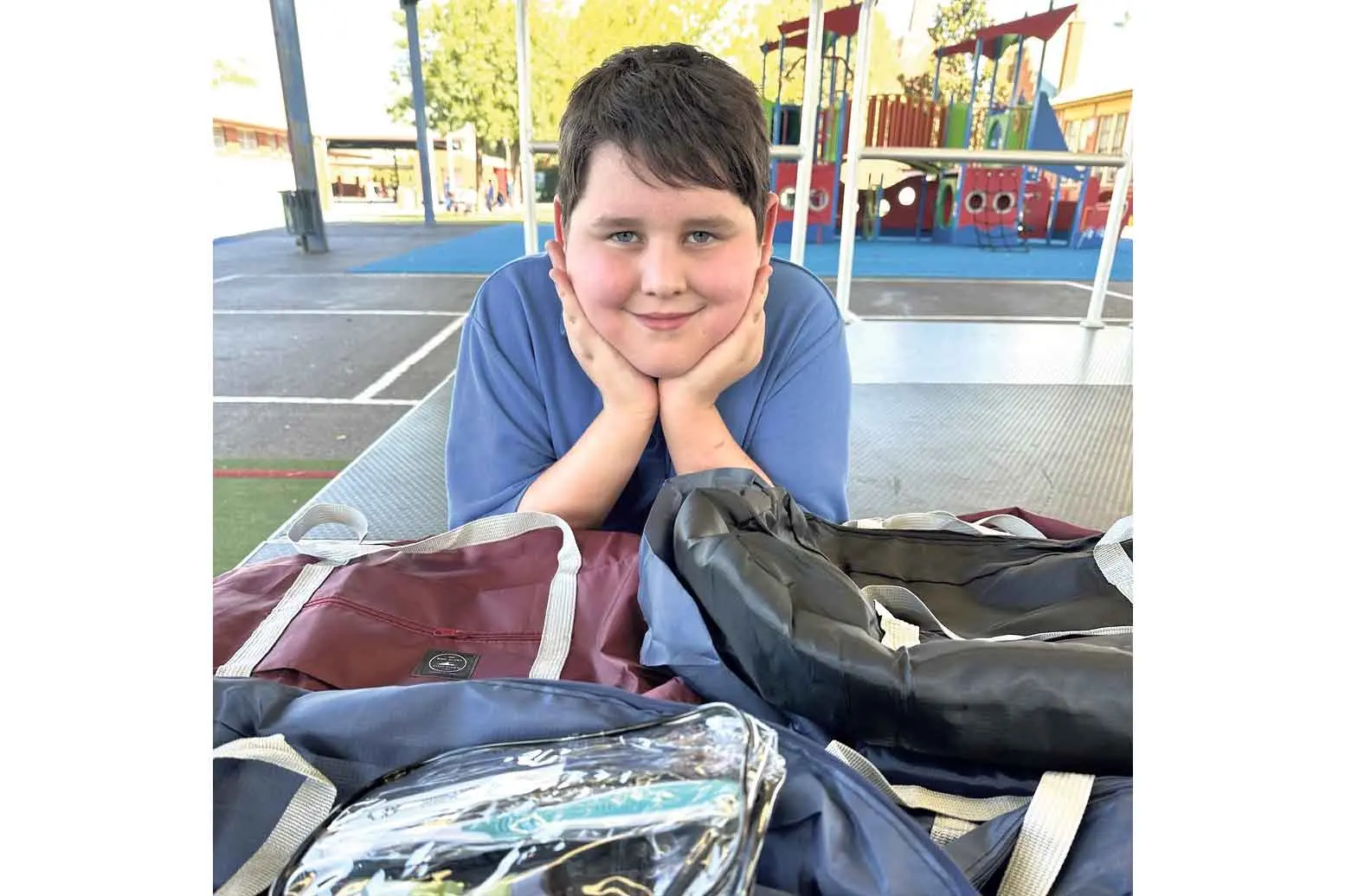 <p>Chance with some of the 140 overnight bags he fundraised for as a gift to his classmates. Photo: Dubbo Photo News. </p>\\n