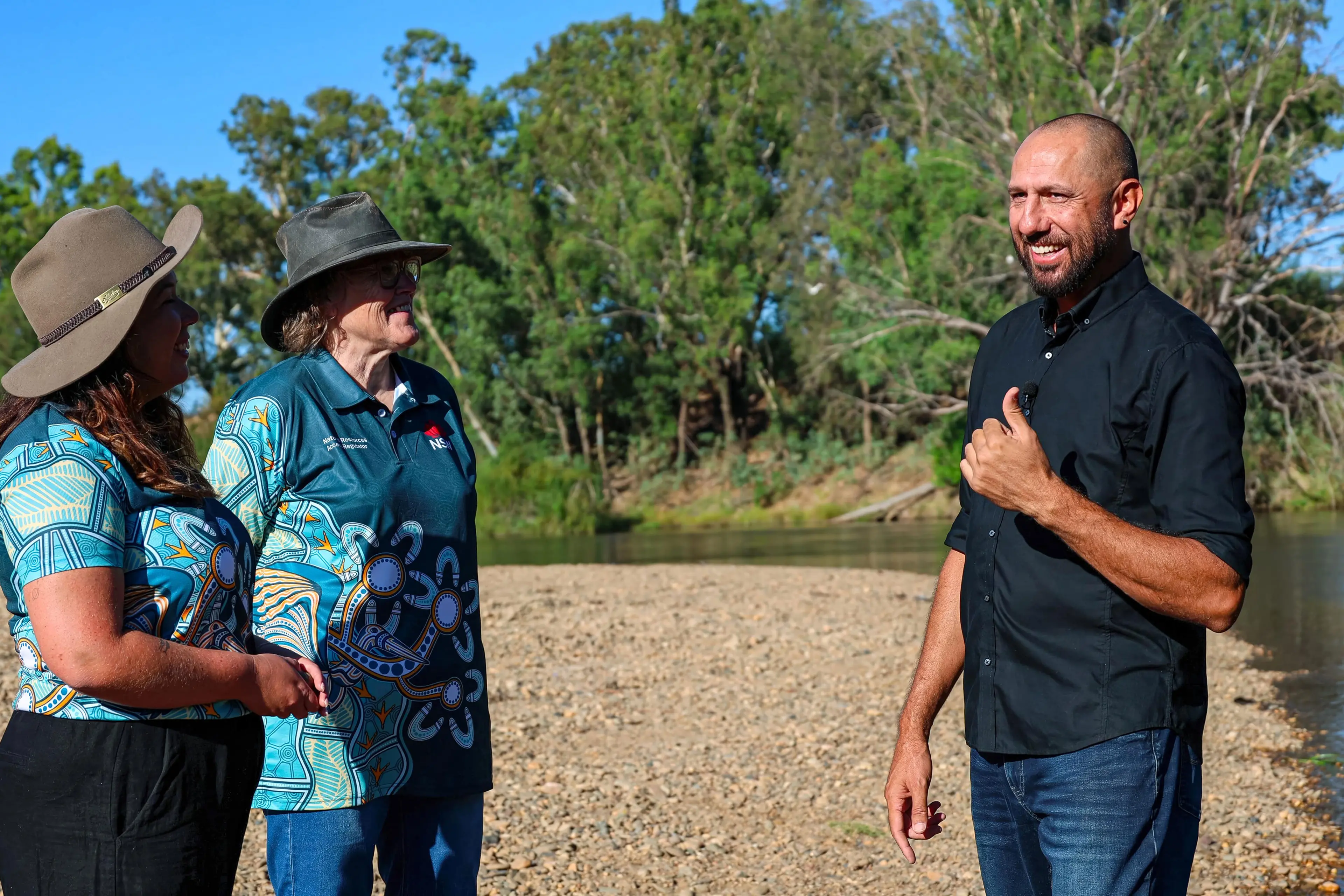 <p>Down by the river; Aboriginal artist, Nathan Peckham with NRAR staff on the banks of the  Macquarie (Wambuul) River. Photo: Supplied</p>\\n