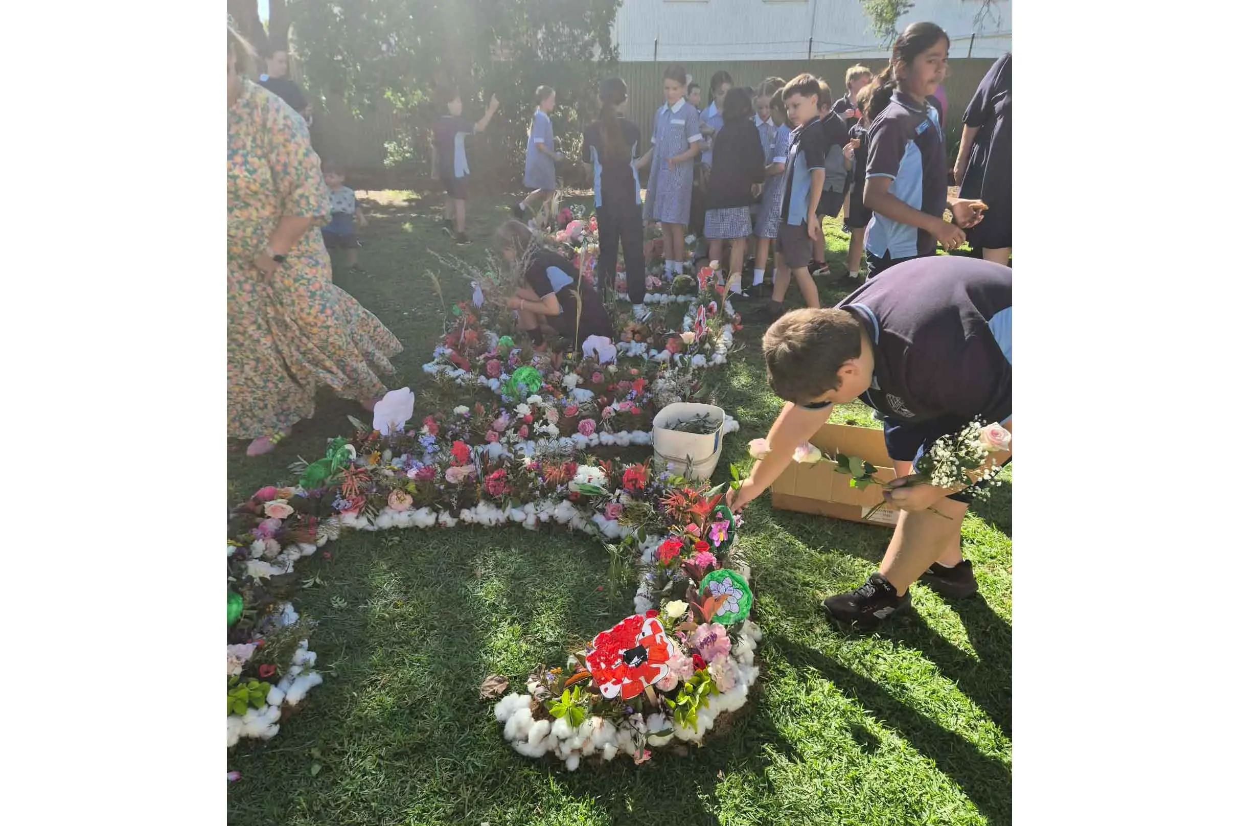 <p>Local school children joined townsfolk in creating the ANZAC flower art on the lawn outside the Trangie Library on April 24. Photos: Alex Gartside. </p>\\n