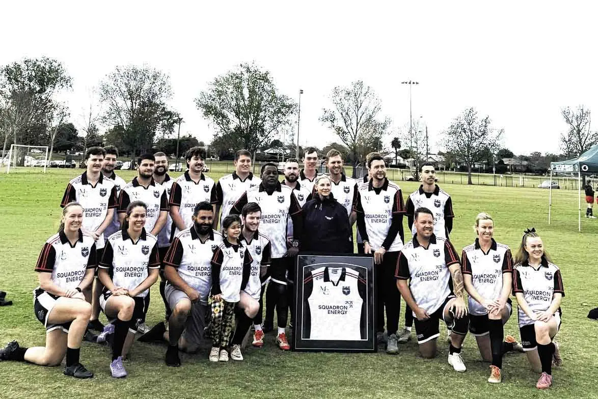 <p>Uungula Wind Farm Community Relations Advisor Jane Sullivan (centre) with the players from the Dubbo Newtown Soccer Club with a framed jersey. Photo: Squadron Energy</p>\\n