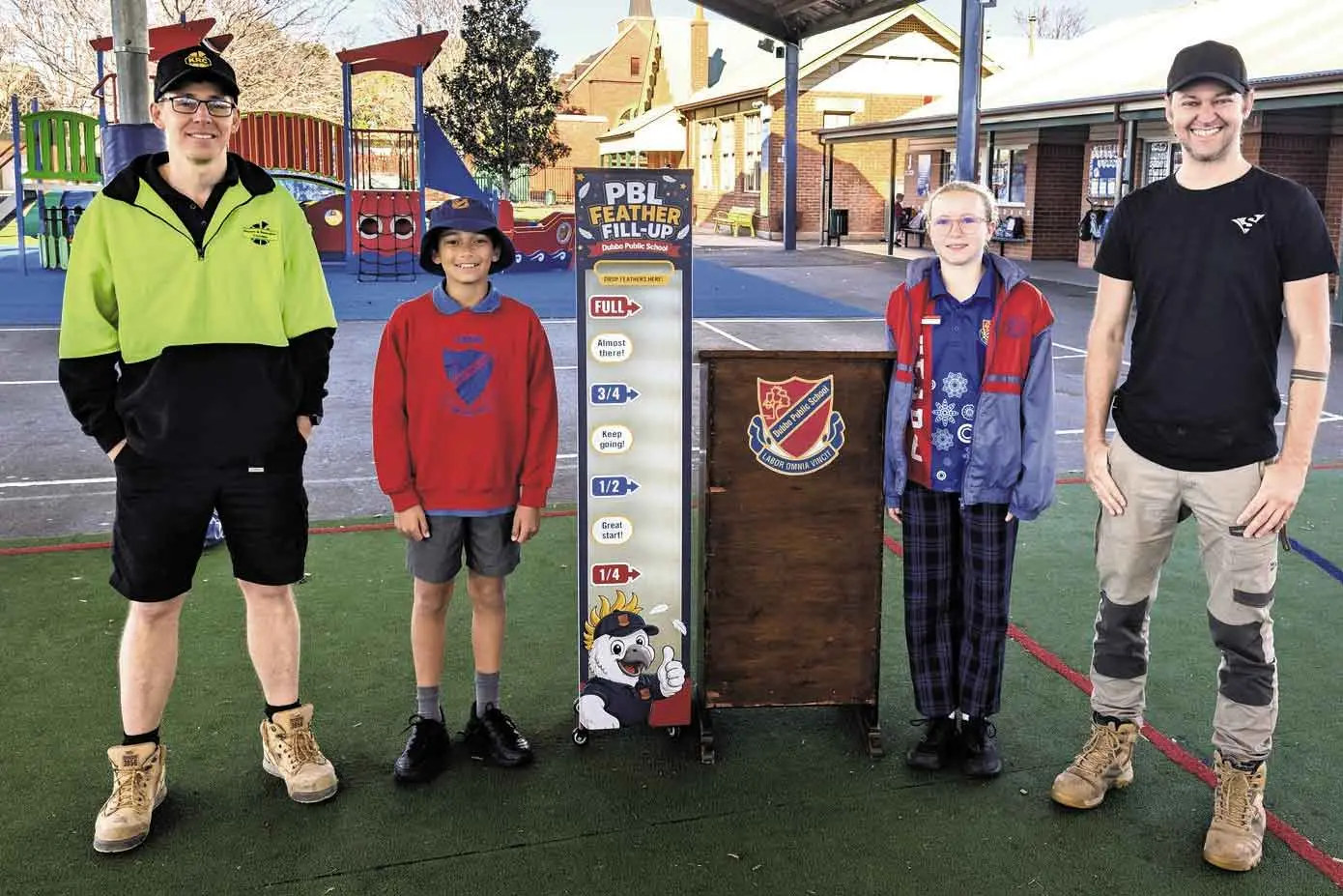 <p>Dubbo Public School students showcase the new PBL Feather Fill-Up alongside representatives from Kitchen & Renovation Concepts and Signarama Dubbo. The whole-school initiative encourages students to work collaboratively and earn rewards. Photo: Dubbo Public School</p>\\n